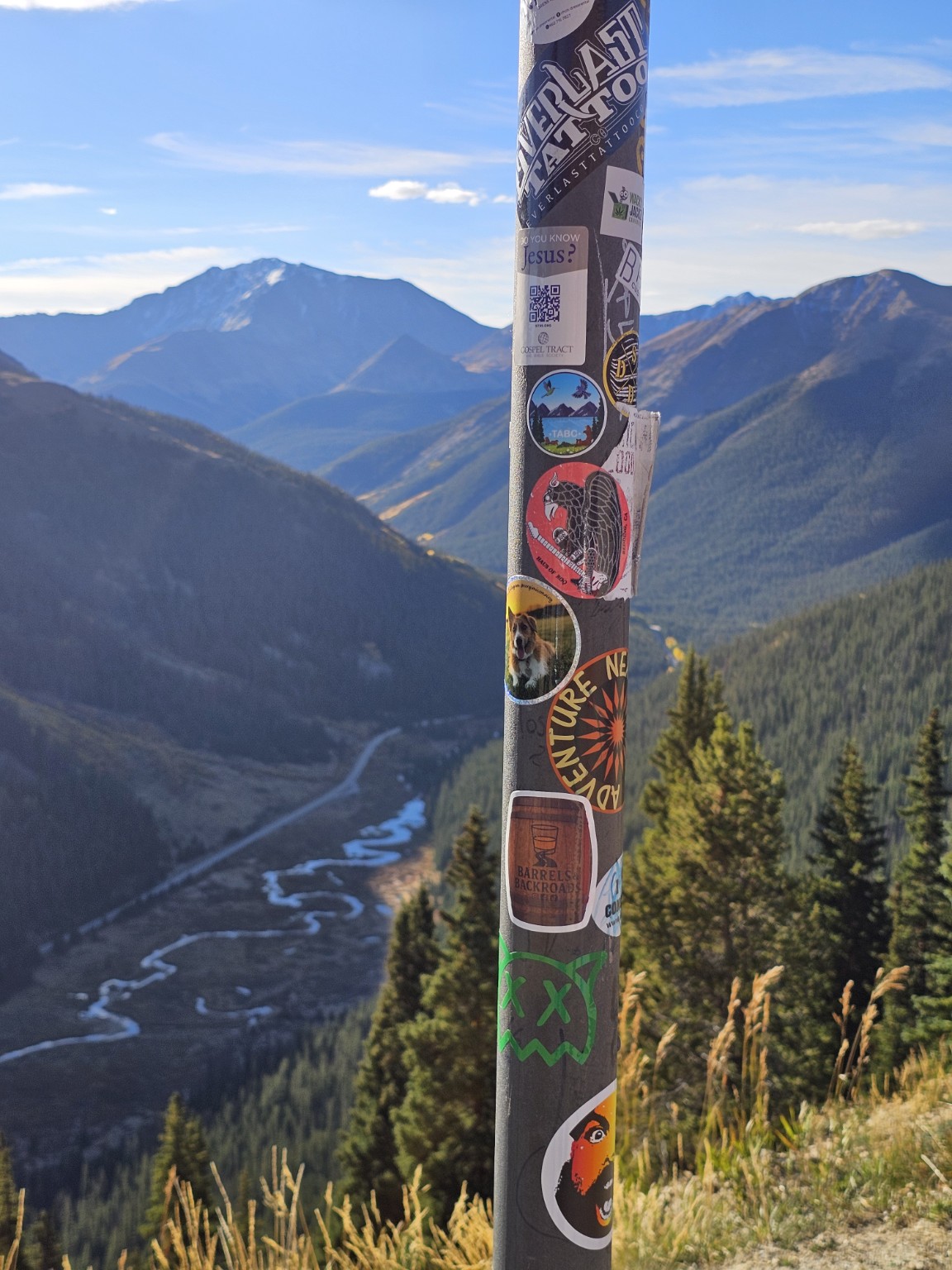 Barrels & Backroads sticker on an overlook pole above a winding mountain valley